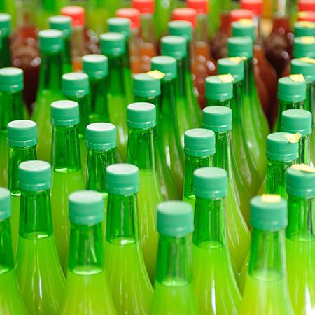 A close up of some filled and capped cider bottles.