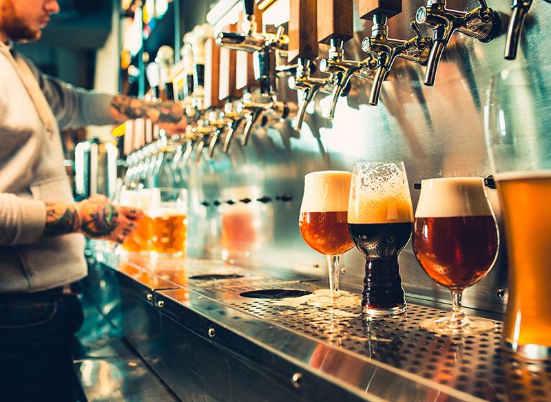 A taproom with beer taps and assorted beers being filled