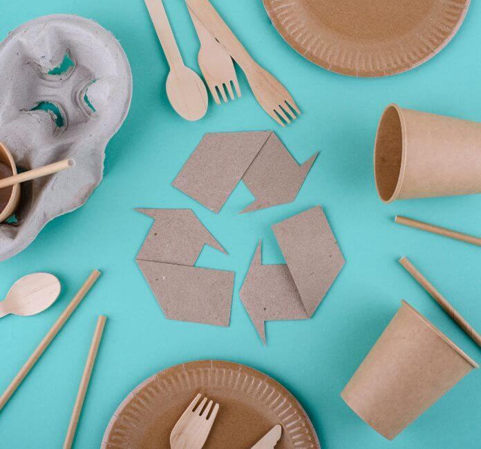 Recycling paper sign with paper recyclable packaging, on a blue background.