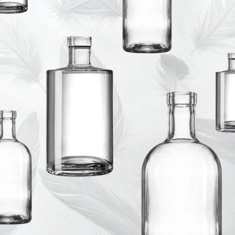 A range of lightweight glass spirits bottles on a feathery light background