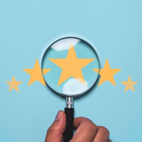 5 yellow stars on a blue background under a magnifying glass.