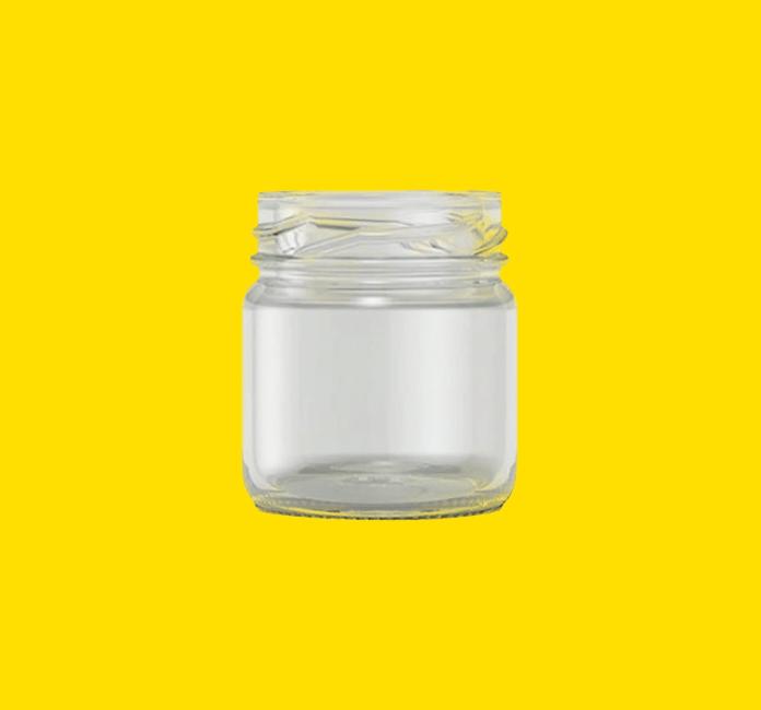 Mini glass food jar on a yellow background.