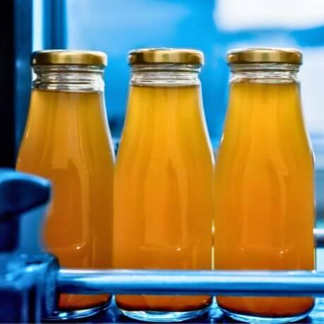 Glass juice bottles with orange juice inside